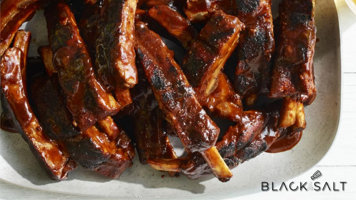 Tempting BBQ Ribs, slow-cooked to tender perfection, slathered in a savory barbecue sauce, offering a delightful and succulent meat option for barbecue lovers.