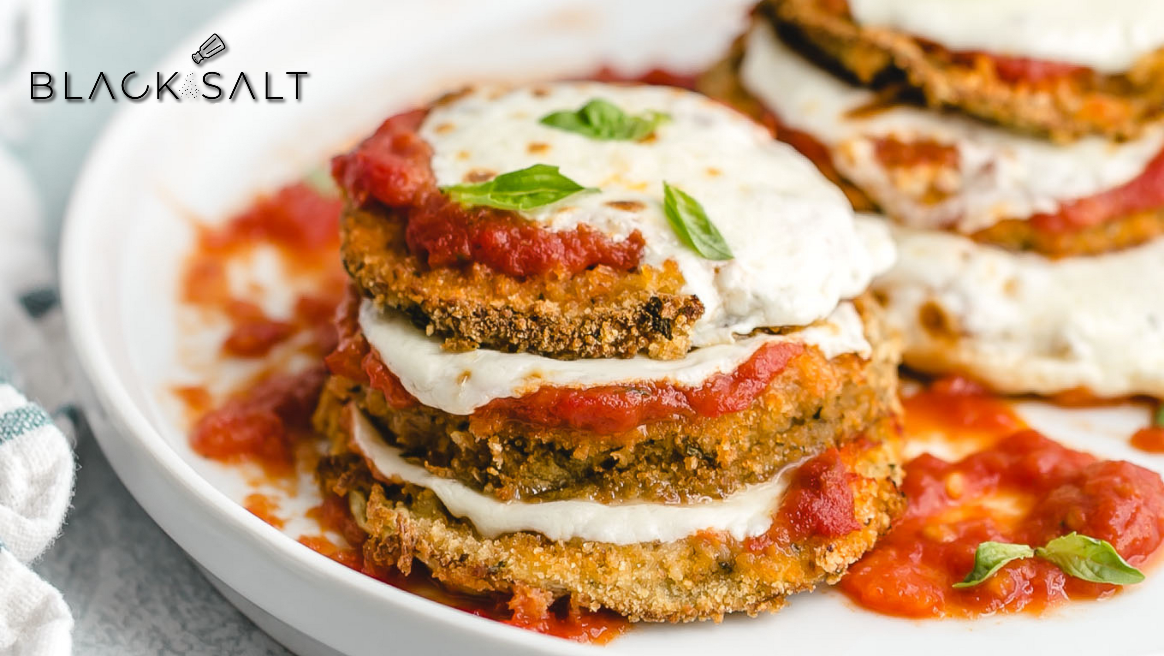 Eggplant Parmesan, a delicious Italian dish featuring breaded and fried eggplant slices layered with tomato sauce, melted cheese, and herbs, creating a flavorful and satisfying vegetarian meal option.