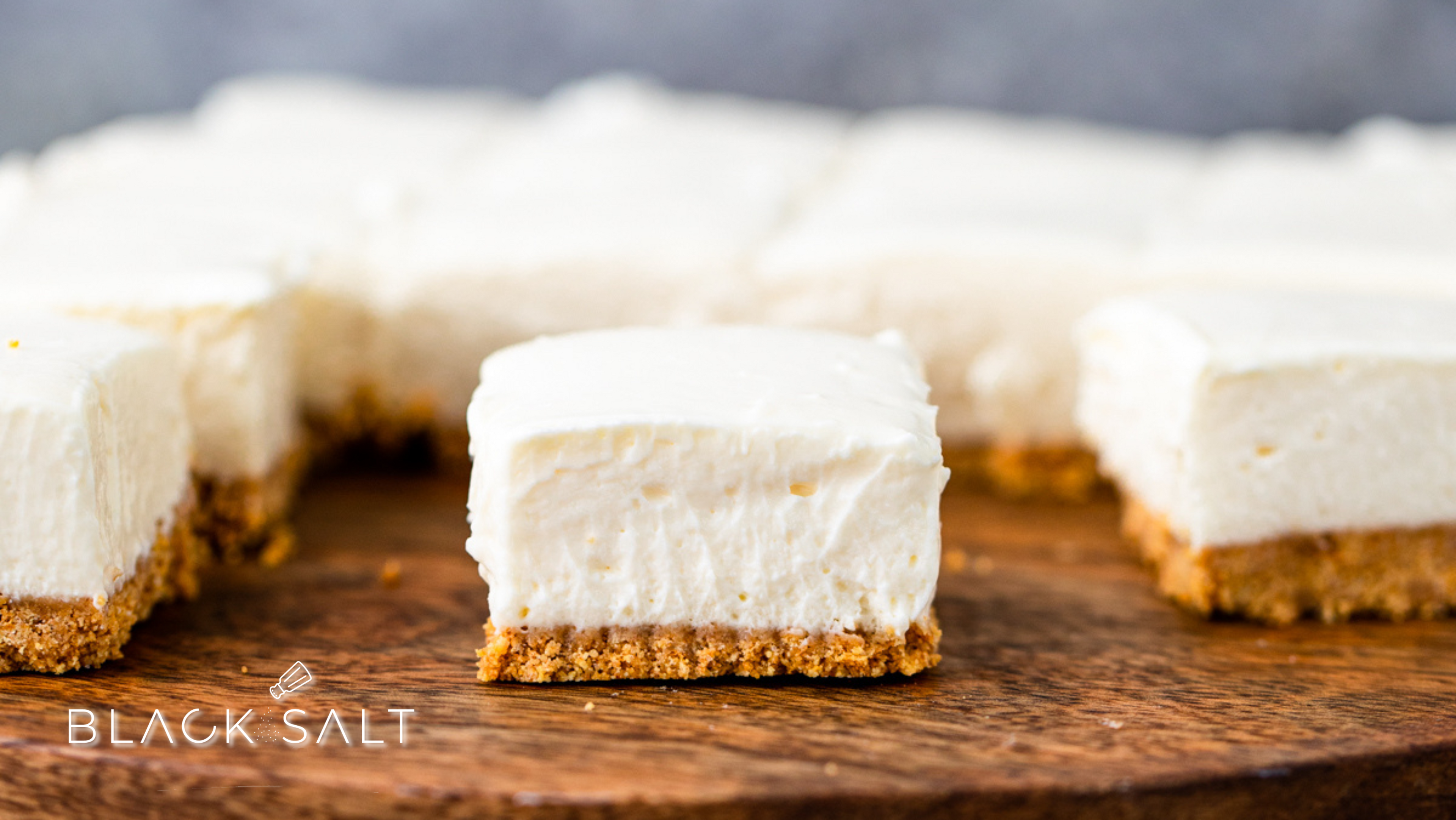 Mascarpone Cheesecake Petit Fours, bite-sized indulgences featuring luscious mascarpone cheesecake layered on a delicate crust, topped with a variety of garnishes, offering a decadent and elegant dessert option for special occasions or events.