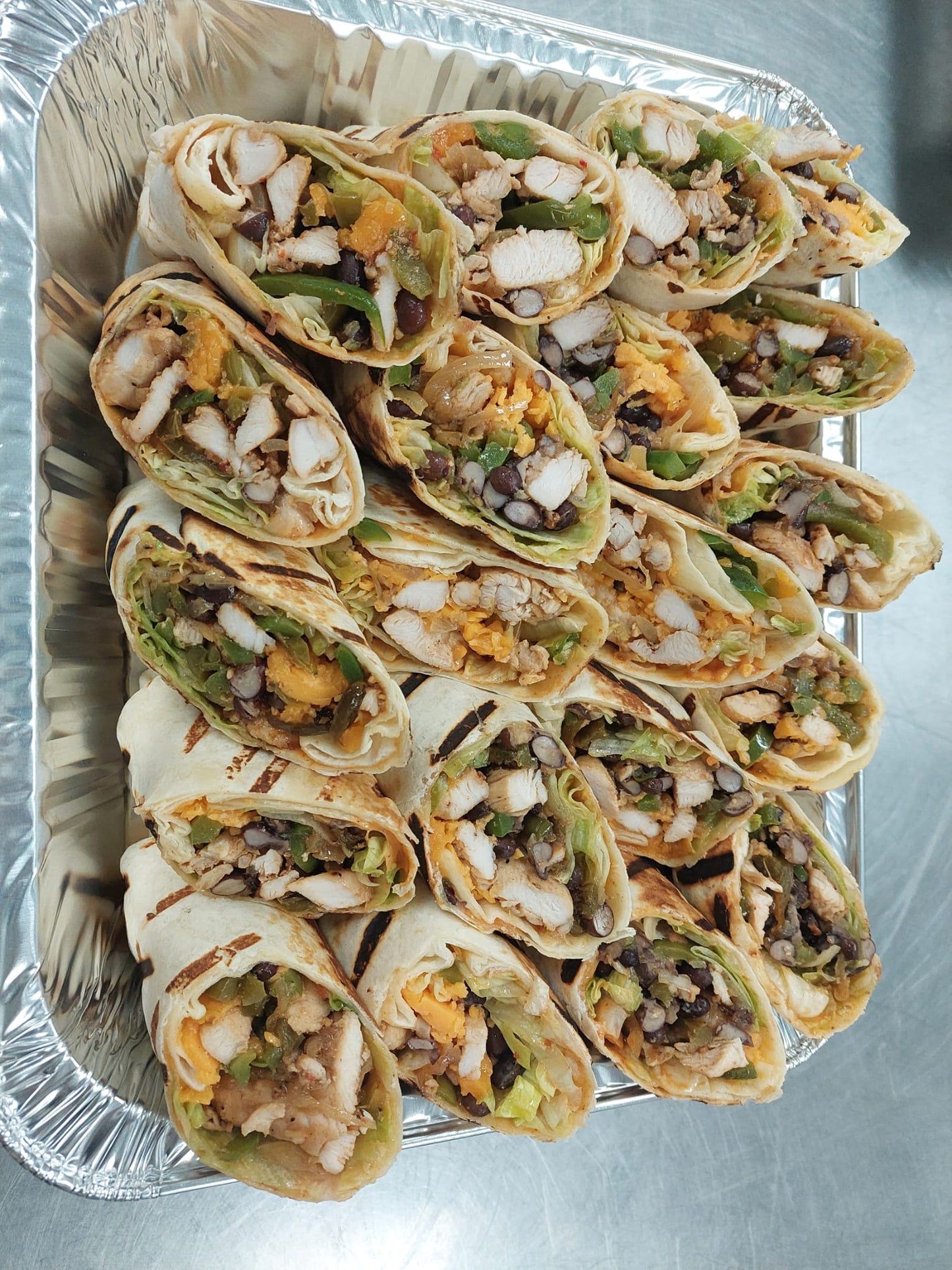 An appetizing assortment of assorted wraps, filled with a variety of delicious ingredients and wrapped in a soft tortilla, offering a convenient and flavorful meal option.