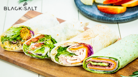 An appetizing assortment of assorted wraps, filled with a variety of delicious ingredients and wrapped in a soft tortilla, offering a convenient and flavorful meal option.