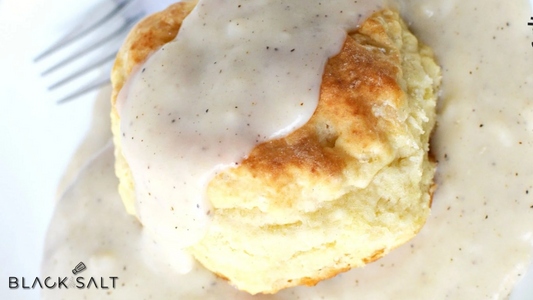 Warm and fluffy biscuits topped with creamy and savory gravy, creating a comforting and indulgent dish perfect for breakfast or brunch.