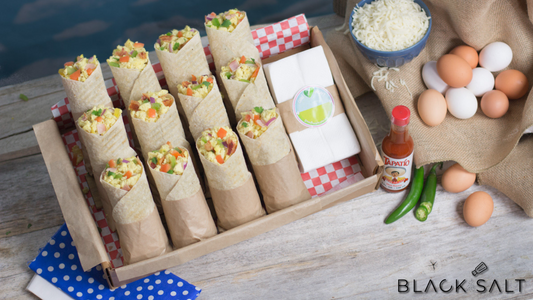 A mouthwatering tray of assorted breakfast burritos, filled with a delicious combination of savory ingredients, perfect for a satisfying and flavorful morning meal.