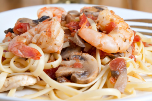 Champagne Shrimp and Pasta, a luxurious and flavorful dish featuring succulent shrimp cooked in a champagne-infused sauce, served over a bed of pasta, creating an elegant and satisfying meal.