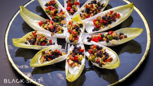 Endive Bites, elegant appetizers featuring endive leaves filled with a variety of delicious toppings, offering a combination of crispness and flavors for a delightful bite-sized treat.
