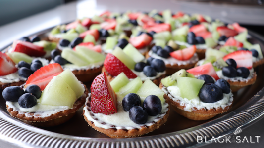 Fruit Tarts, delicate pastry shells filled with a luscious cream or custard base, topped with an assortment of fresh fruits, creating a visually stunning and delectable dessert option.
