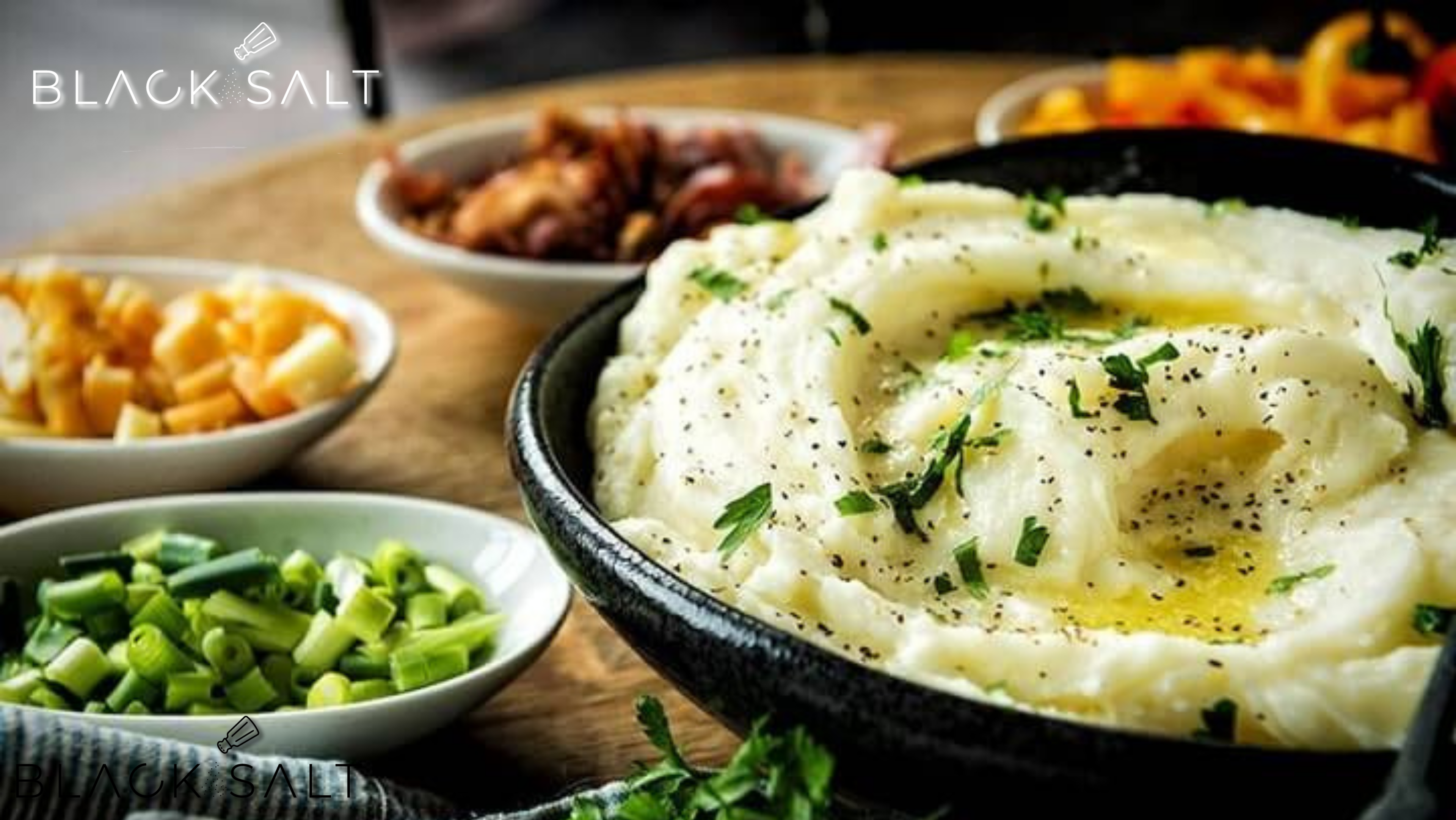 Make Your Own Mashed Potato Bar, a customizable setup featuring creamy mashed potatoes as the base, accompanied by a selection of toppings and garnishes such as butter, gravy, shredded cheese, bacon bits, chives, and sour cream, allowing guests to personalize their mashed potato creations.