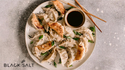 Potstickers, savory dumplings filled with a mixture of meats and vegetables, pan-fried to a crispy bottom and steamed to perfection, offering a delicious and popular appetizer or snack option.