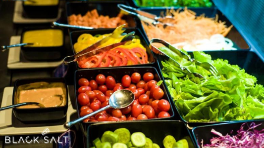 Self-Serve Salad Bar, a customizable setup featuring a variety of fresh greens, vegetables, toppings, dressings, and protein options, allowing guests to create their own personalized salads, offering a healthy and interactive dining experience.
