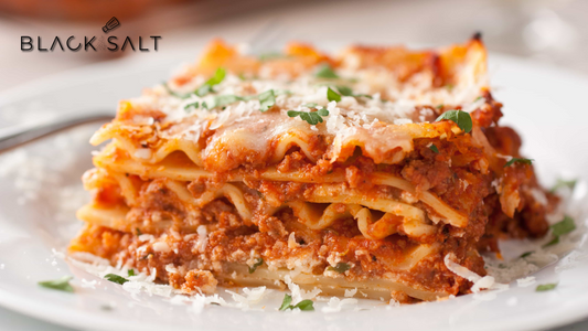Traditional Lasagna, layers of tender pasta sheets, savory meat sauce, creamy ricotta cheese, and melted mozzarella, baked to perfection, offering a classic and comforting Italian dish.